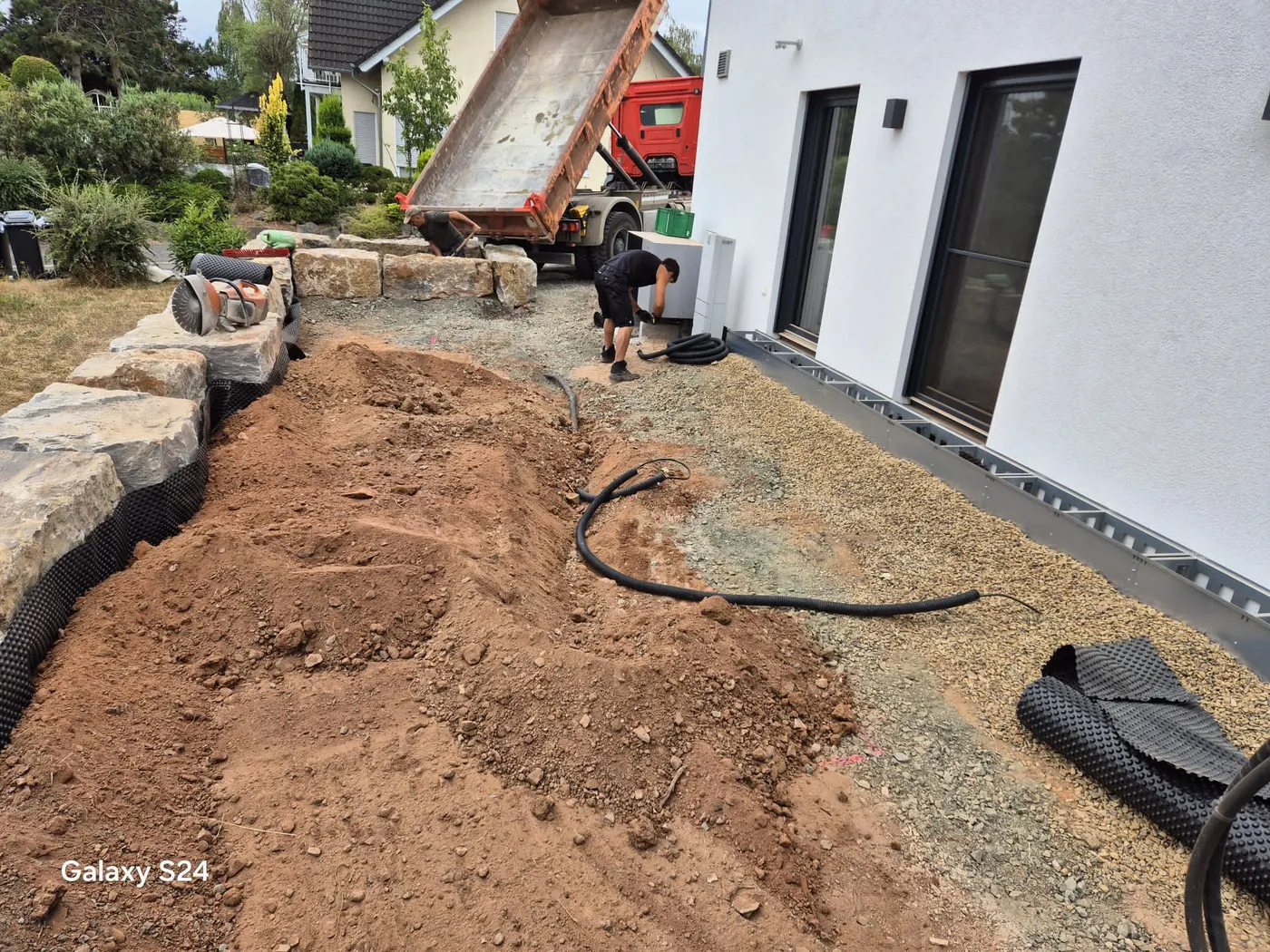Arbeiten am Flächenaufbau mit LKW und Handwerkzeug